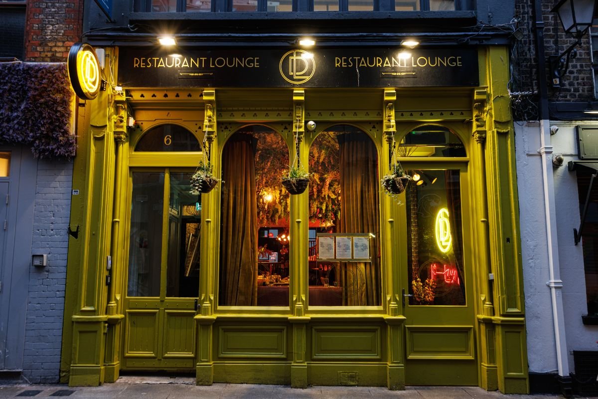 The iconic facade of The DL restaurant in Temple Bar, Dublin, inviting diners with its warm glow and vibrant neon signage.
