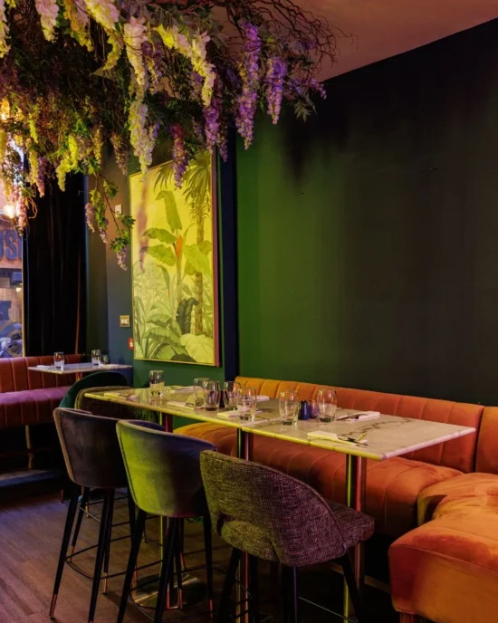 Chic dining area with botanical decor and hanging flowers, offering an enchanting dining atmosphere in the heart of Temple Bar.